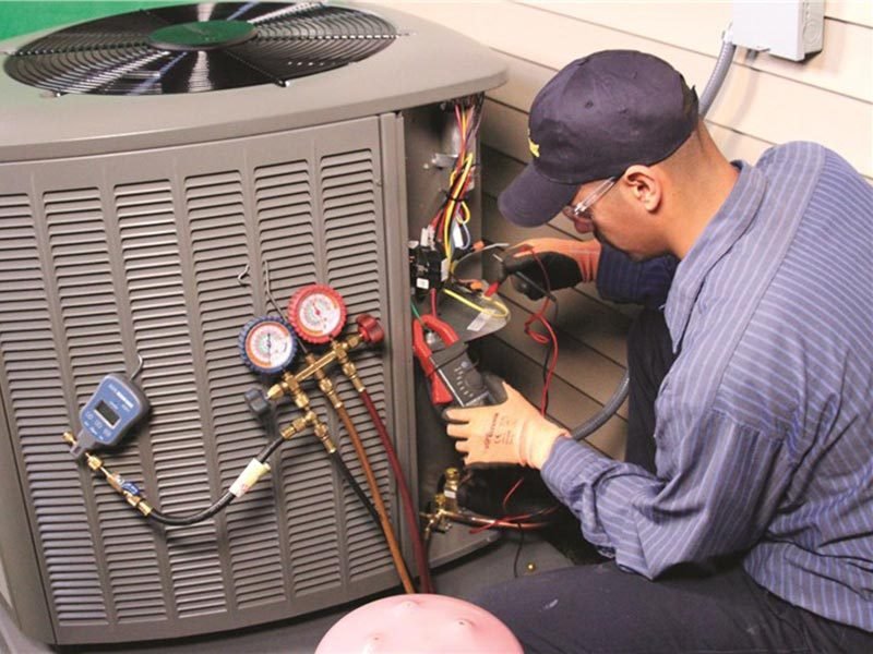 Technician performing air conditioning maintenance